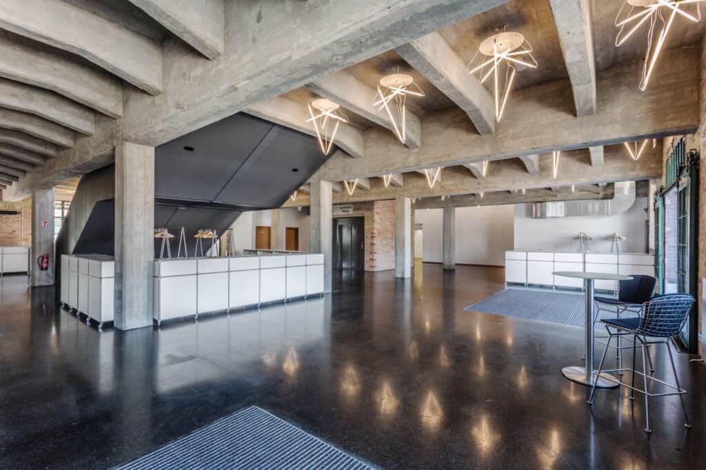 Die geräumige Lobby des WECC, gekennzeichnet durch ihren eleganten Betonboden und moderne Ästhetik.